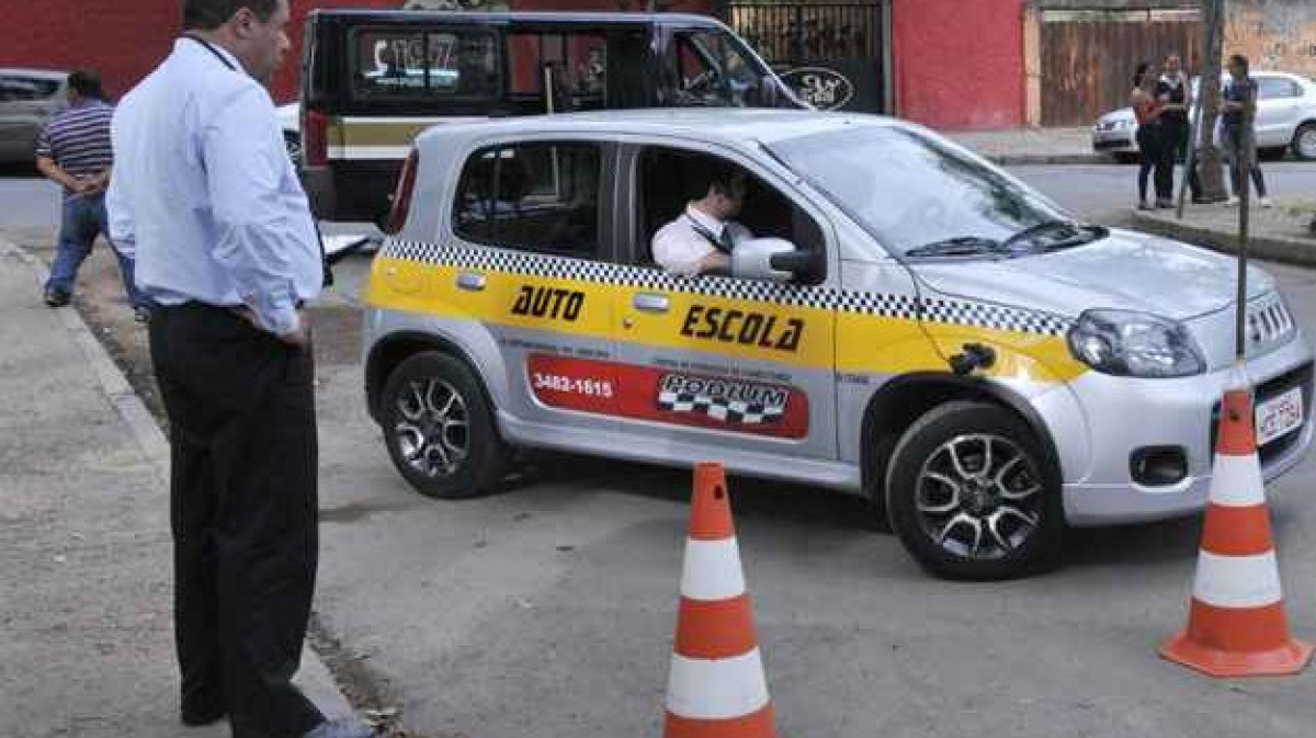 Fiat Uno de autoescola em rua com cones e examinador ao lado