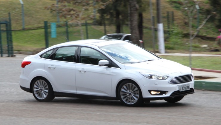 ford focus titanium 2.0 fastback powershift modelo 2015 branco de frente no asfalto em movimento