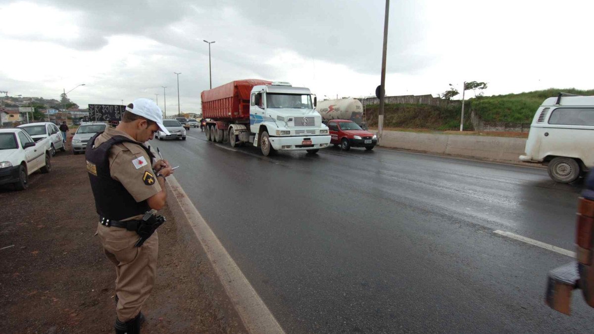 Policial em rodovia em Minas Gerais aplicando multa em motorista infrator