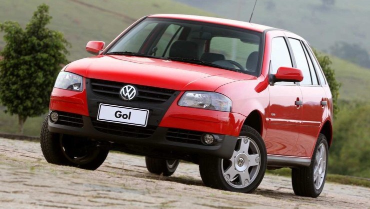 Volkswagen Gol vermelho visto de frente na área natural