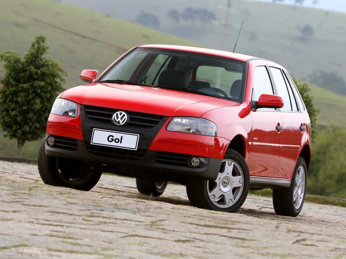 Volkswagen Gol vermelho de frente em área de natureza