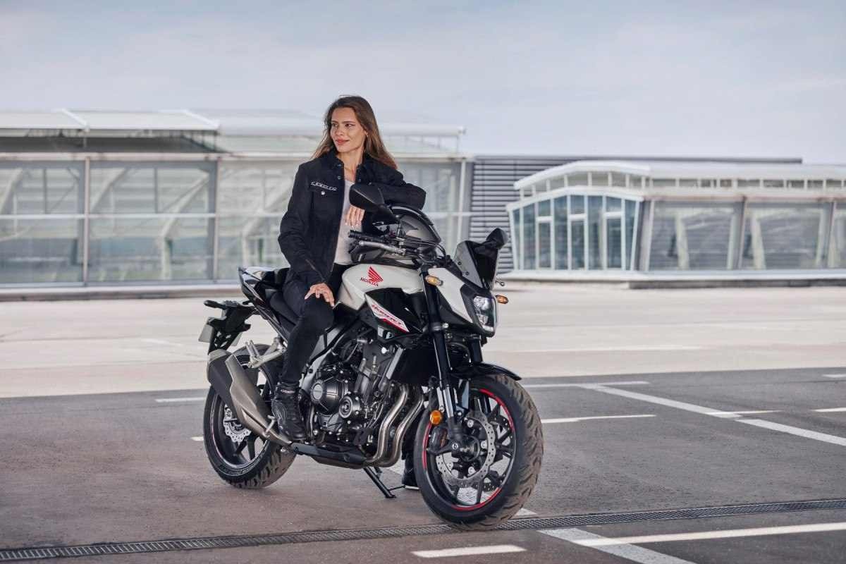 Salão de Milão 2023 Honda CB 500 Hornet branco e preto de frente mulher no banco no asfalto.jpg