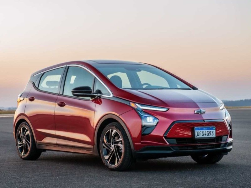 Carro elétrico dianteiro vermelho Chevrolet Bolt 2023 estático no asfalto