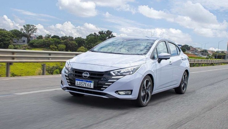 Nissan Versa Exclusive 2024 cinza, 1.6 Flex, de frente, em movimento em rodovia
