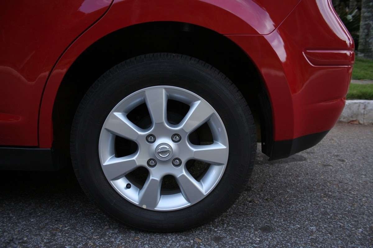 Nissan Tiida SL 1.8 Flex modelo 2010 vermelho estático roda de liga leve no asfalto