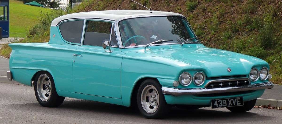 1962 Ford Consul Classic está em uma estrada asfaltada com um morro coberto de grama atrás.