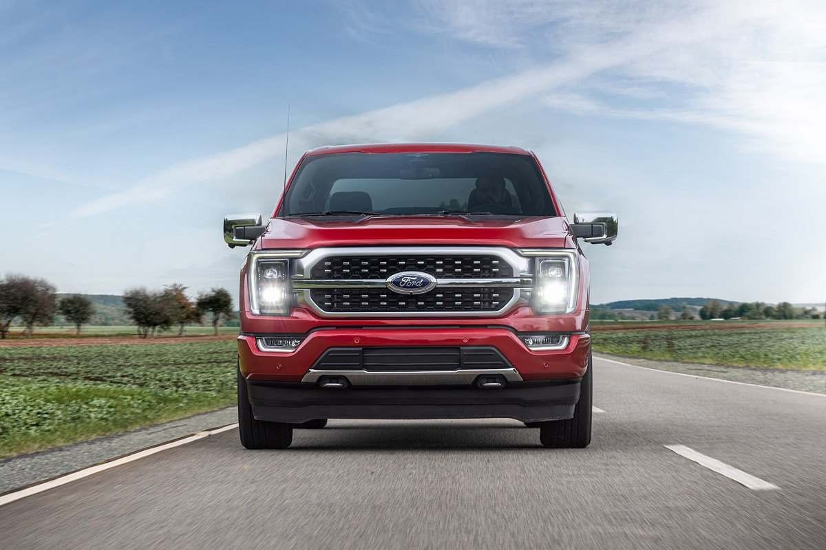 Frente da Ford F-150 Platinum vermelha em estrada com fundo de dia ensolarado