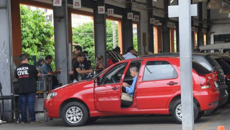 Fila de carros é vista sendo vistoriada em pátio do antigo Detran por Policiais Civis.