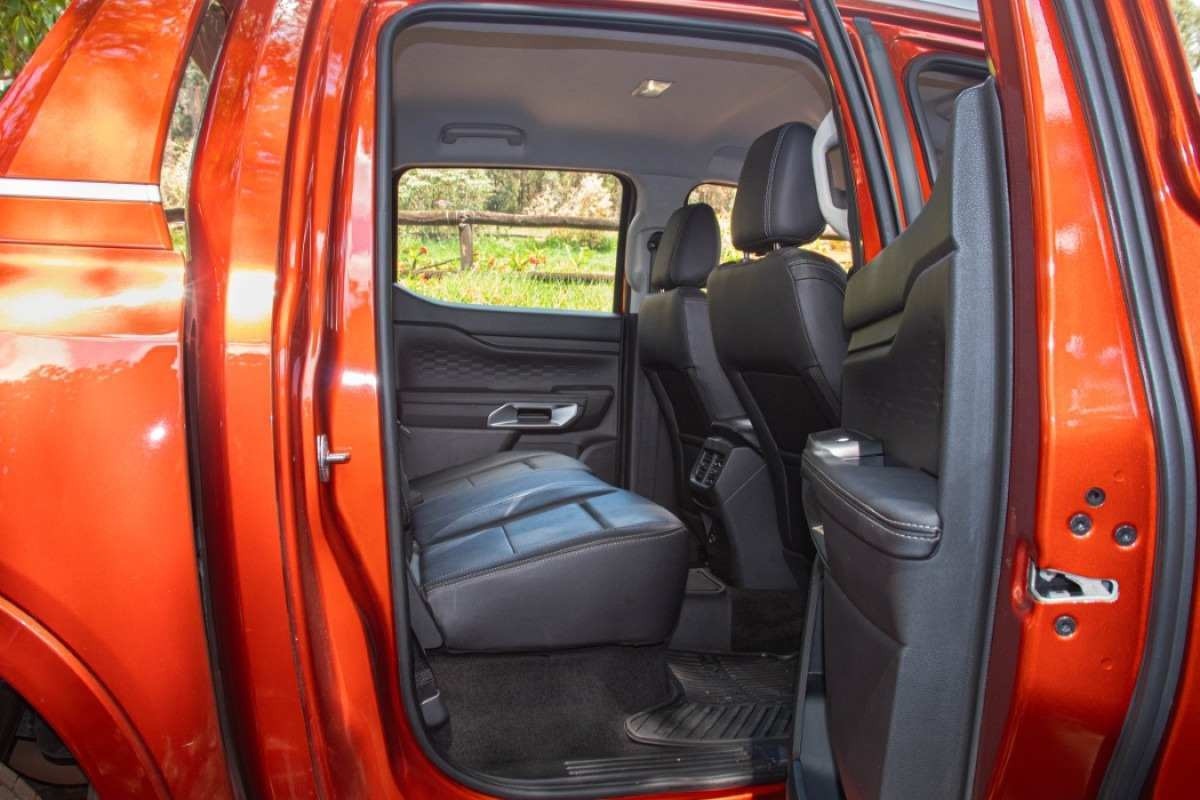 Ford Ranger 3.0 V6 Limited modelo 2024 vermelha interior porta aberta banco traseiro no asfalto.jpg