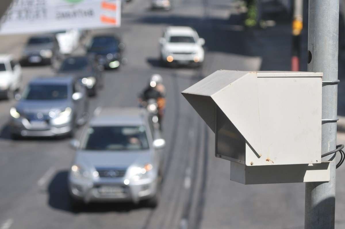 Radar instalado em um poste em uma estrada com circulação de carros e motos