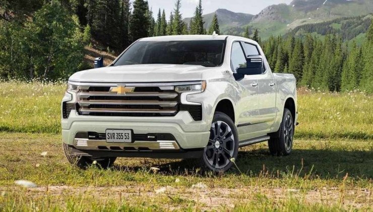 Silverado High Country 2024 em campo gramado, ao fundo h&aacute; &aacute;rvores e uma montanha.