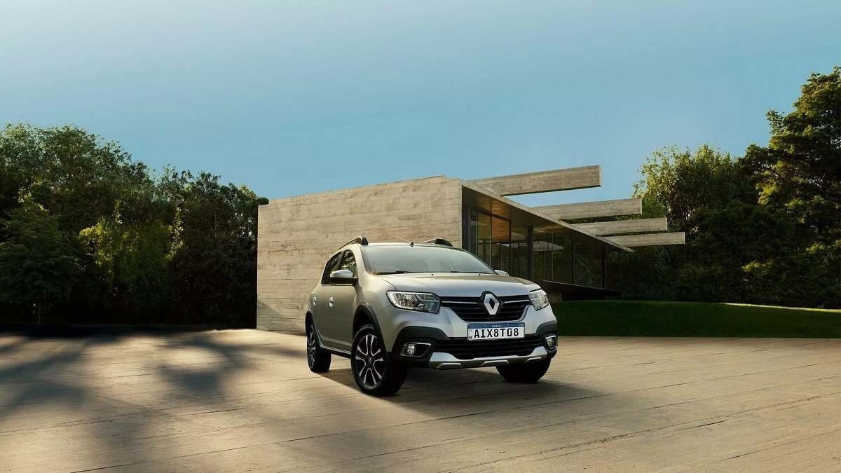 Renault Stepway trafega em pavimento com árvores ao lado e céu claro ao fundo.