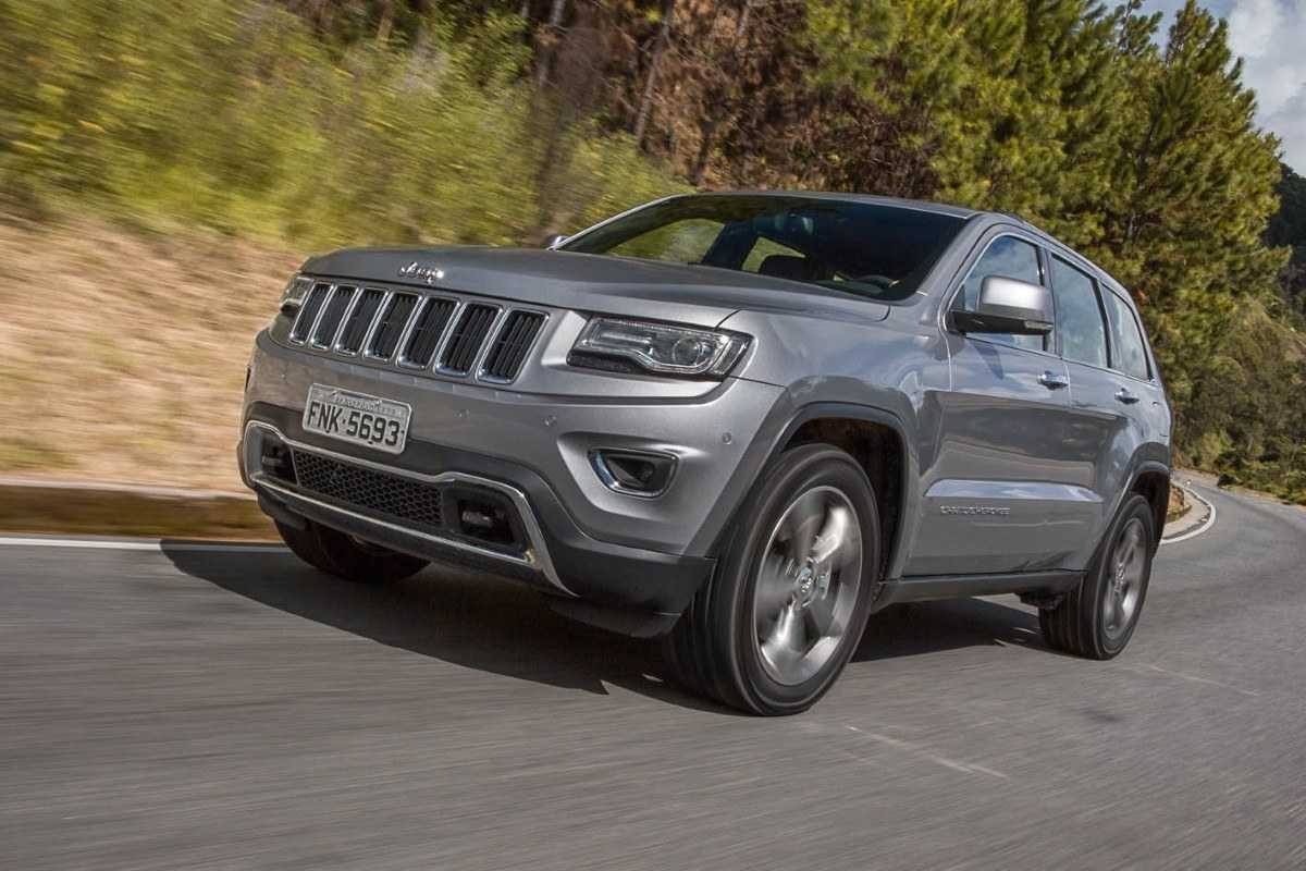 Jeep Grand Cherokee modelo 2014 a diesel cinza de frente em movimento no asfalto