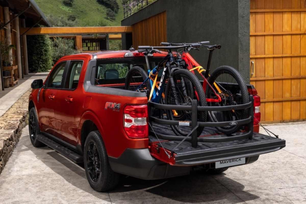 Ford Maverick Lariat FX4 vermelha de traseira com bicicletas na caçamba aberta estática na garagem