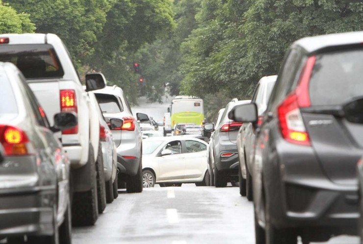 Tr&acirc;nsito com carros divididos em duas faixas