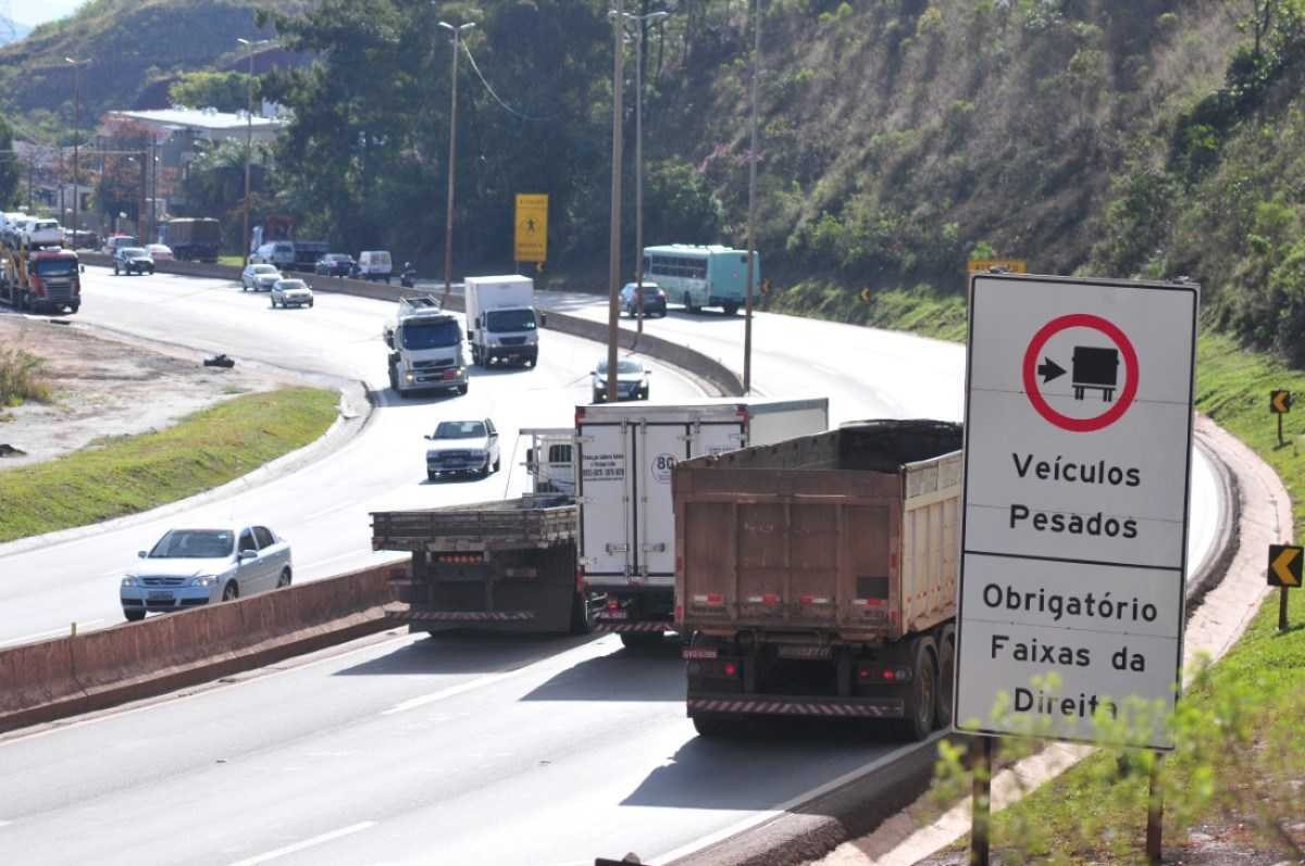 Tráfego de caminhões em faixa da esquerda em rodovia de Minas com três caminhões emparelhados