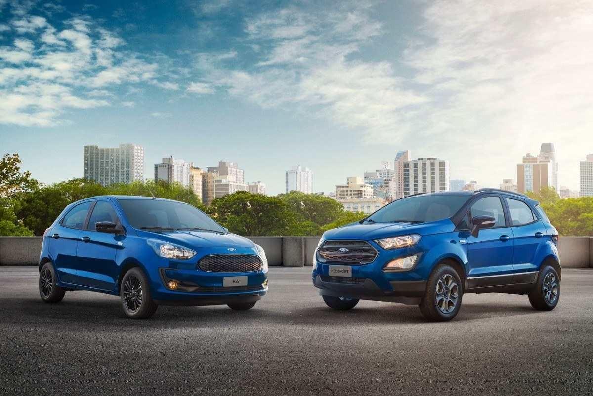 Ford Ka e EcoSport da série especial 100 Anos, na cor azul, estacionados de frente, a 90 graus um do outro, com paisagem urbana ao fundo