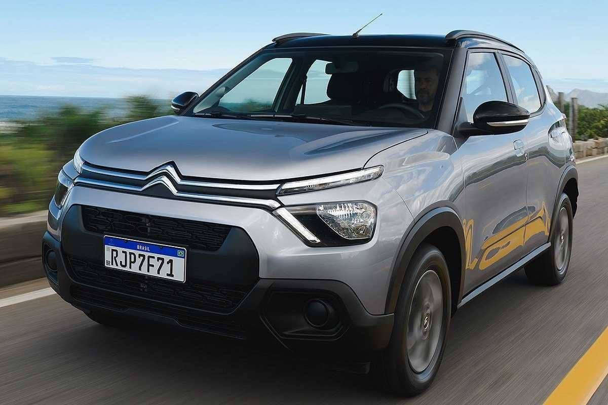 Citroën C3 Live prata andando em estrada com grama e o céu azul ao fundo.