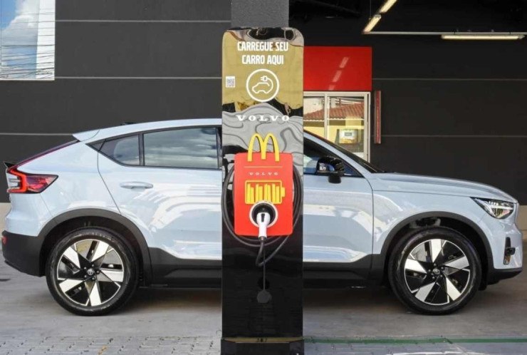 Carregador elétrico Volvo instalado em um restaurante McDonald's com um carro elétrico Volvo C40 ao fundo