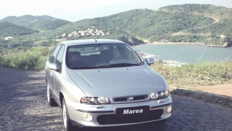 Fiat Marea prata de frente estacionado em estrada litorânea 