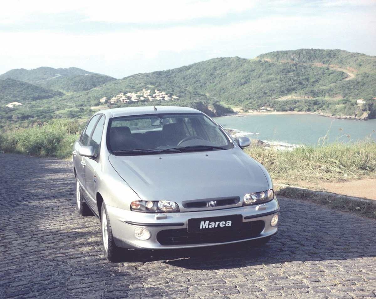 Fiat Marea prata de frente estacionado em estrada litorânea 