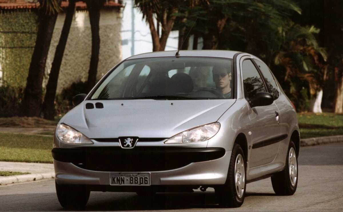  Peugeot 206 1.0 cinza de frente em movimento em rua 