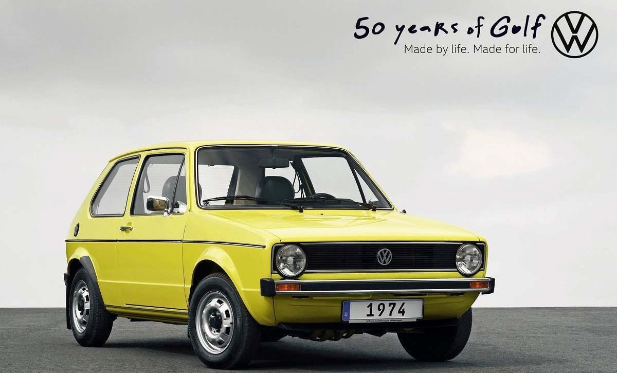 Volkswagen Golf amarelo de 1974 visto em chão preto e fundo cinza esfumaçado.