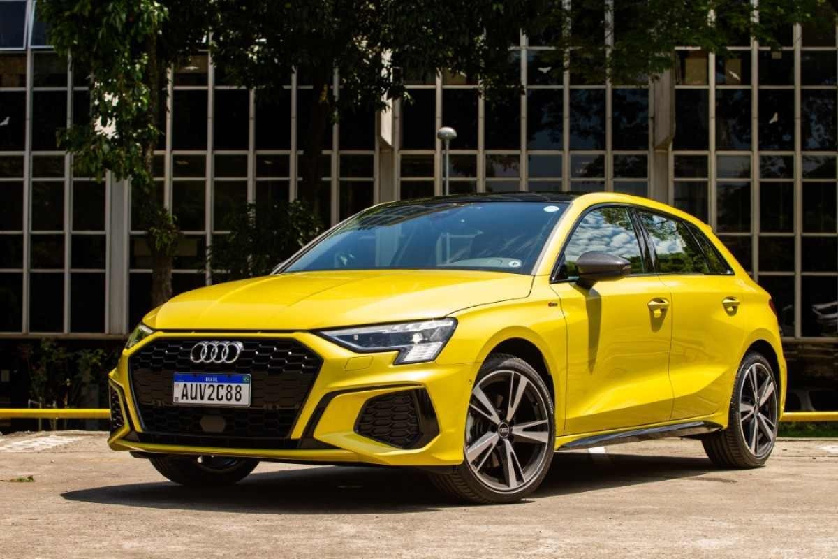 Audi A3 Sportback S-Line modelo 2021 amarelo de frente na calçada