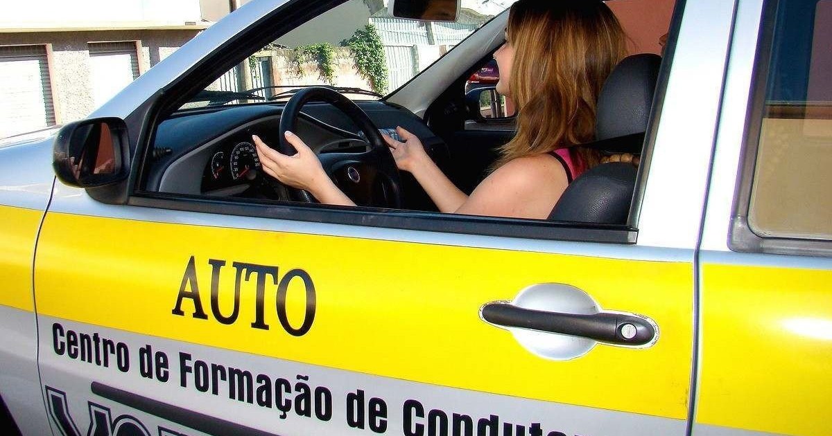 Mulher de cabelo ruivo dirige carro de auto escola