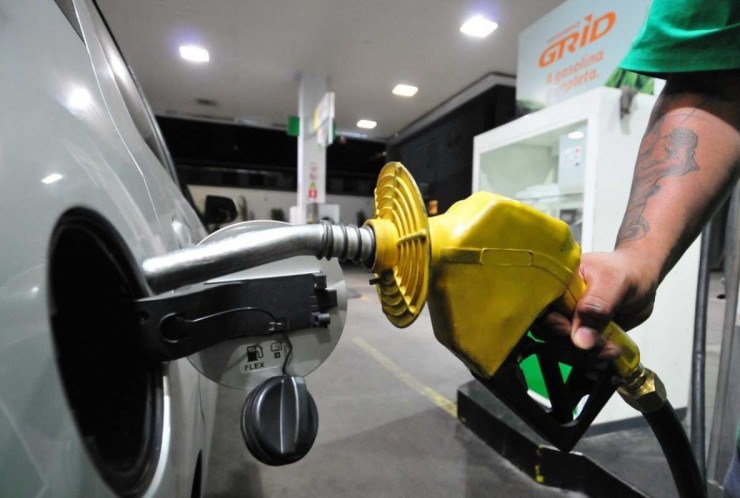 Bico de bomba de gasolina abastecendo o tanque de um carro prata em posto de combustível; Diesel e gasolina ficaram mais caros após reajuste da Petrobras