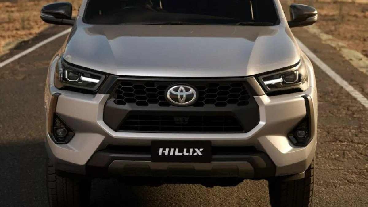 Toyota Hilux 2025 prata com foco na dianteira anda em rua asfaltada
