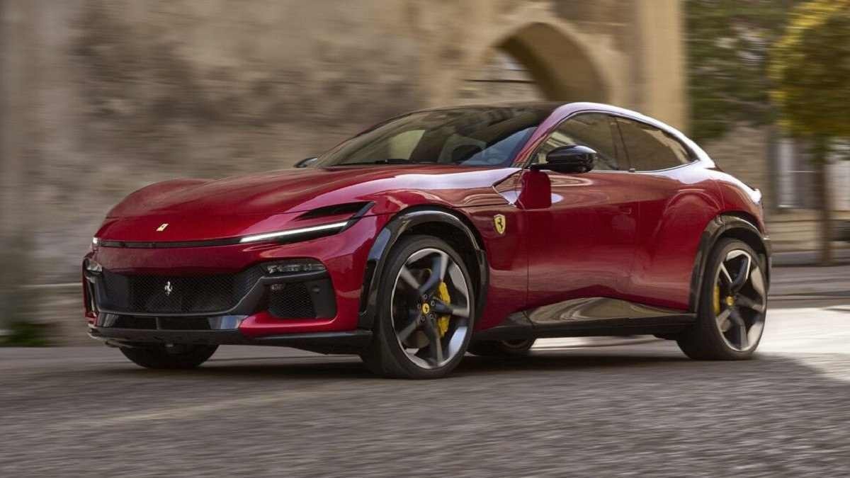 Ferrari Purosangue vermelho anda em rua de pedras, ao fundo parede há também de pedras que possui um arco.