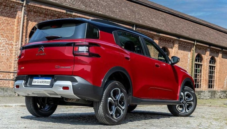 Citro&euml;n C3 Aircross vermelho com pr&eacute;dio de arquitetura cl&aacute;ssica ao fundo.