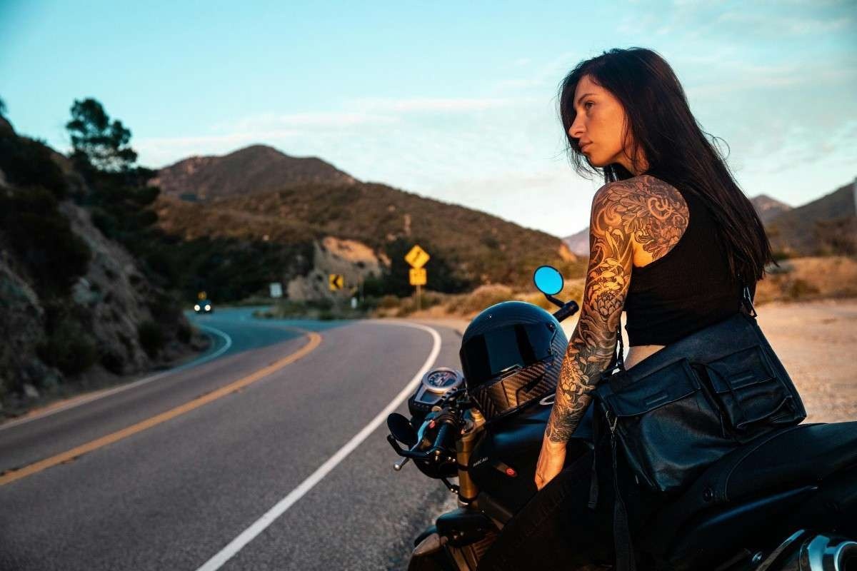 Mulher de moto na beira da estrada estática
