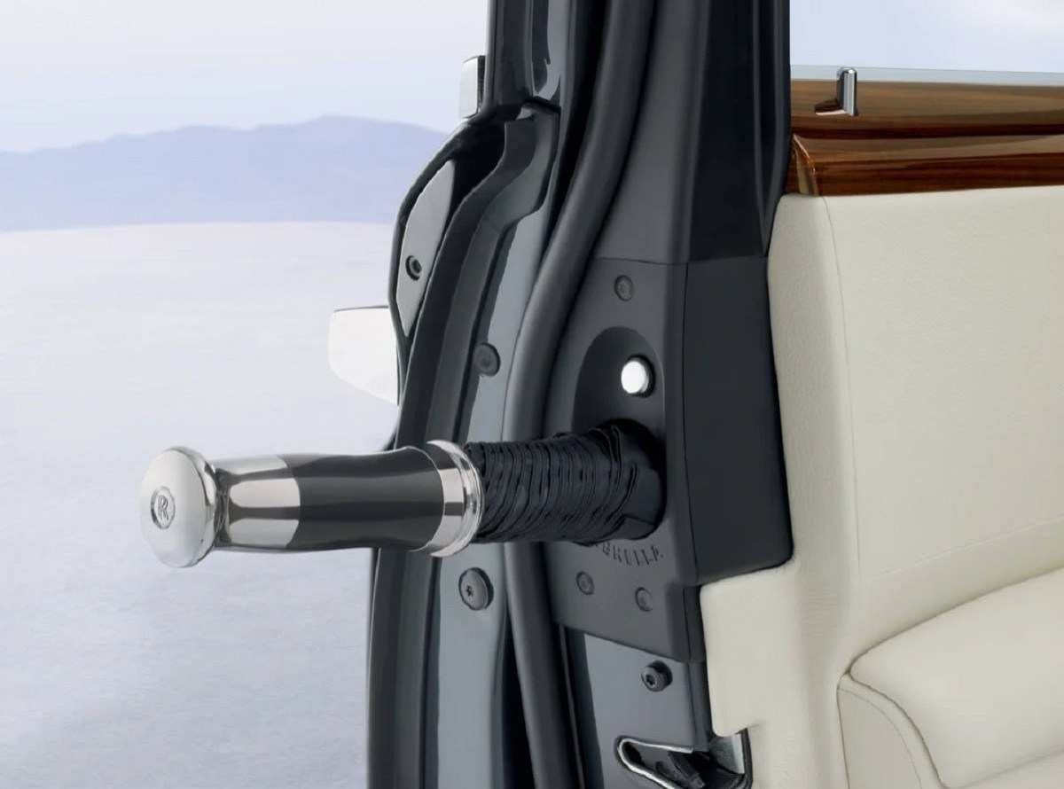 Detalhe de um guarda-chuva inserido em um compartimento próprio, localizado no batente da porta de caro Rolls Royce