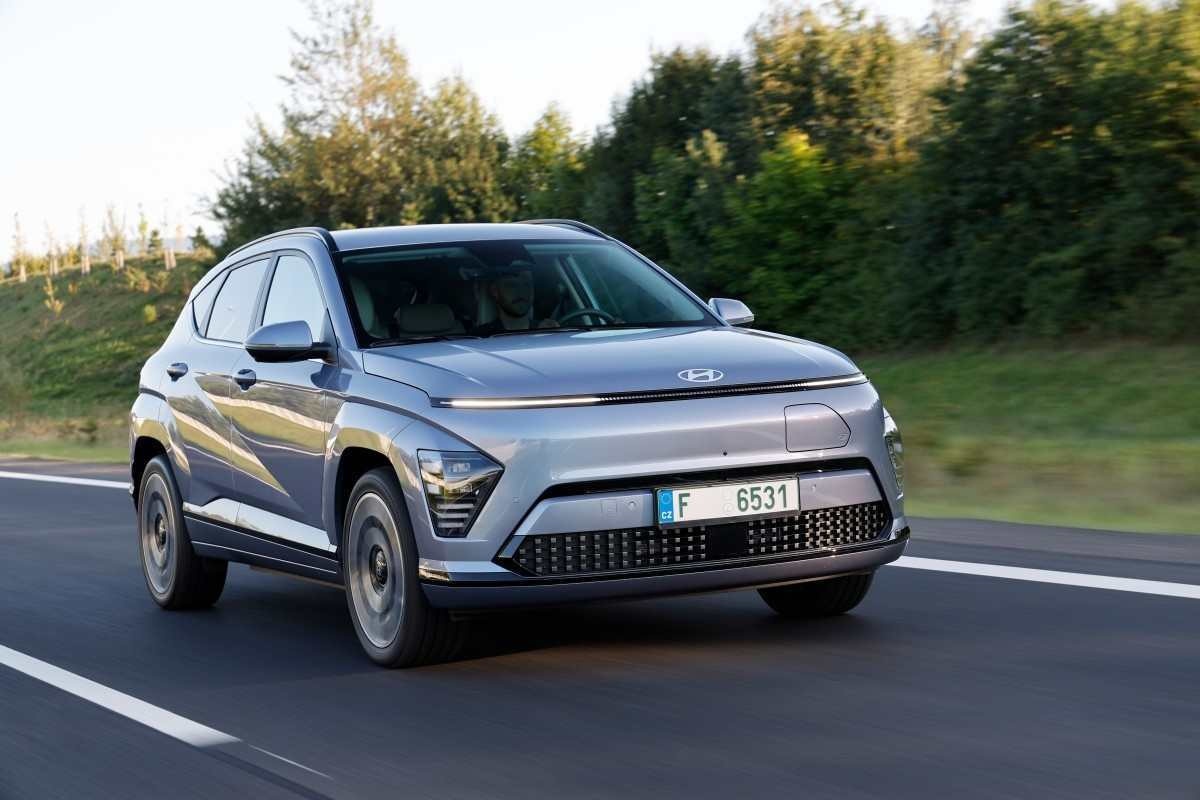 Hyundai Kona EV modelo 2024 prata de frente em movimento no asfalto