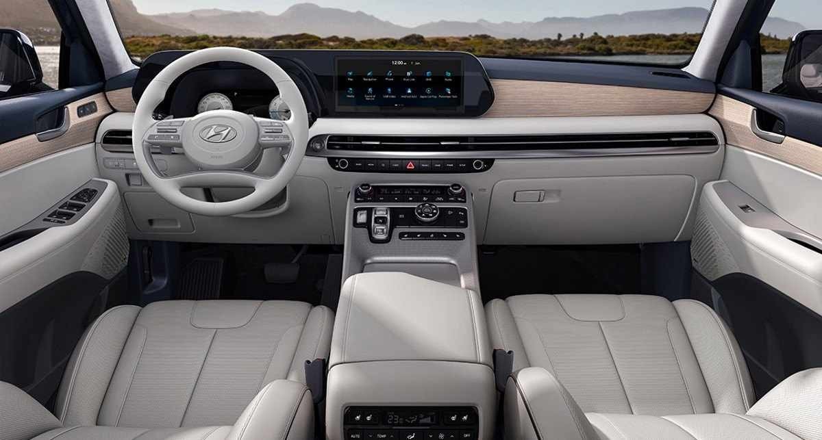 Hyundai Palisade 2024 cinza escuro interior painel e bancos dianteiros estático no asfalto