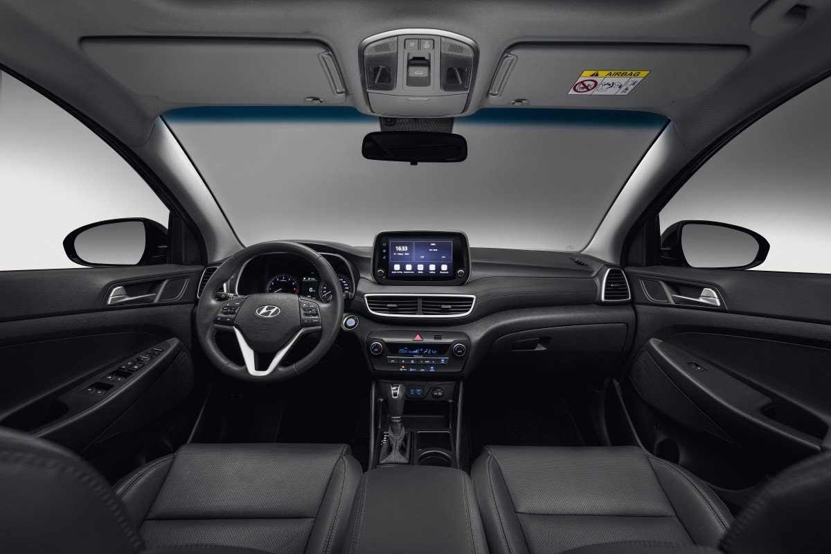 Hyundai Tucson modelo 2024 cinza interior painel e bancos dianteiros estático no estúdio