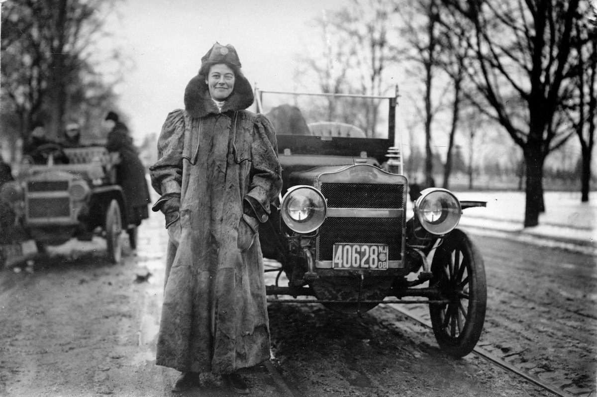 Mulher com roupa de inverno em frente a autmóvel