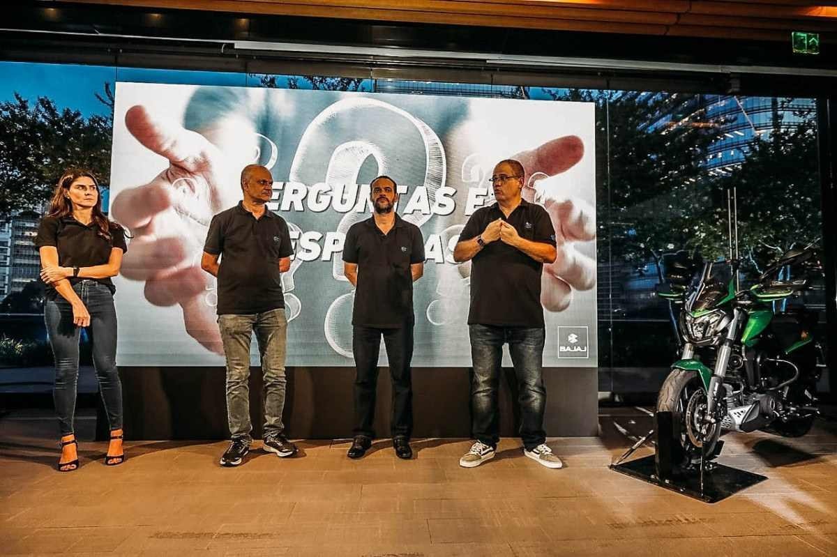 Quatro profissionais da Bajaj Motos, em pé, durante evento de comemoração de 1 ano da empresa no Brasil 