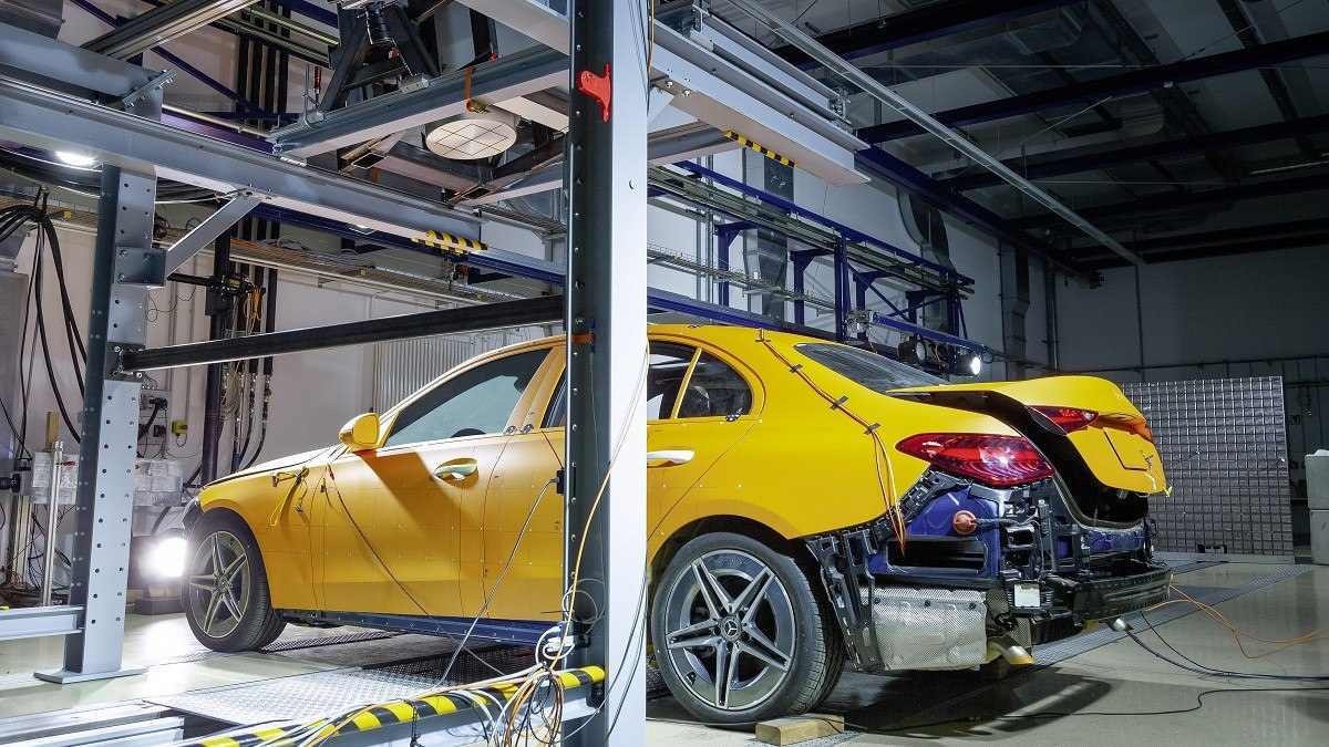 Carro de teste amarelo da Mercedes-Benz em laboratório dentro de "gaiola" de metal.