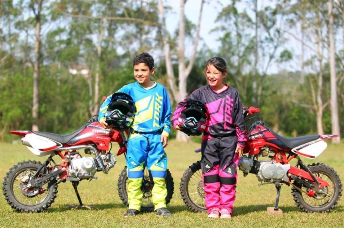 Crianças vestidas para pilotar moto