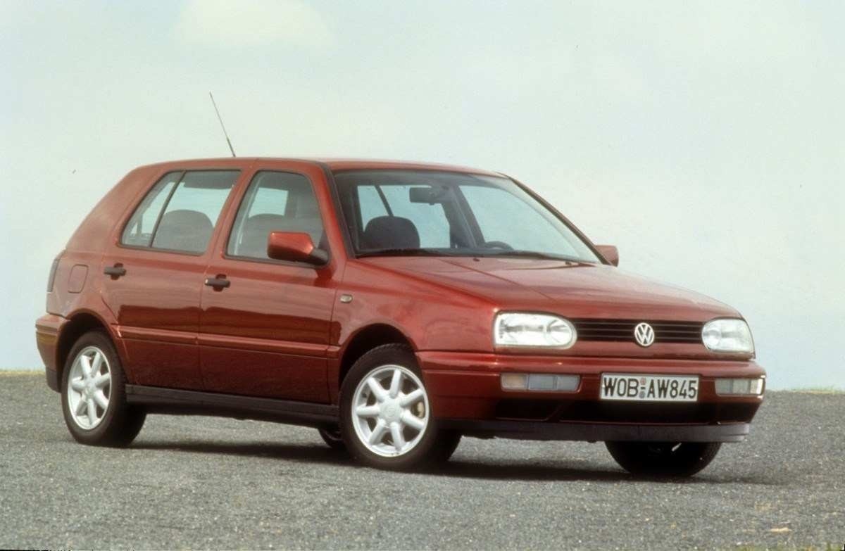 Volkswagen Golf de terceira geração, vermelho metálico, de frente, estacionado em local asfaltado