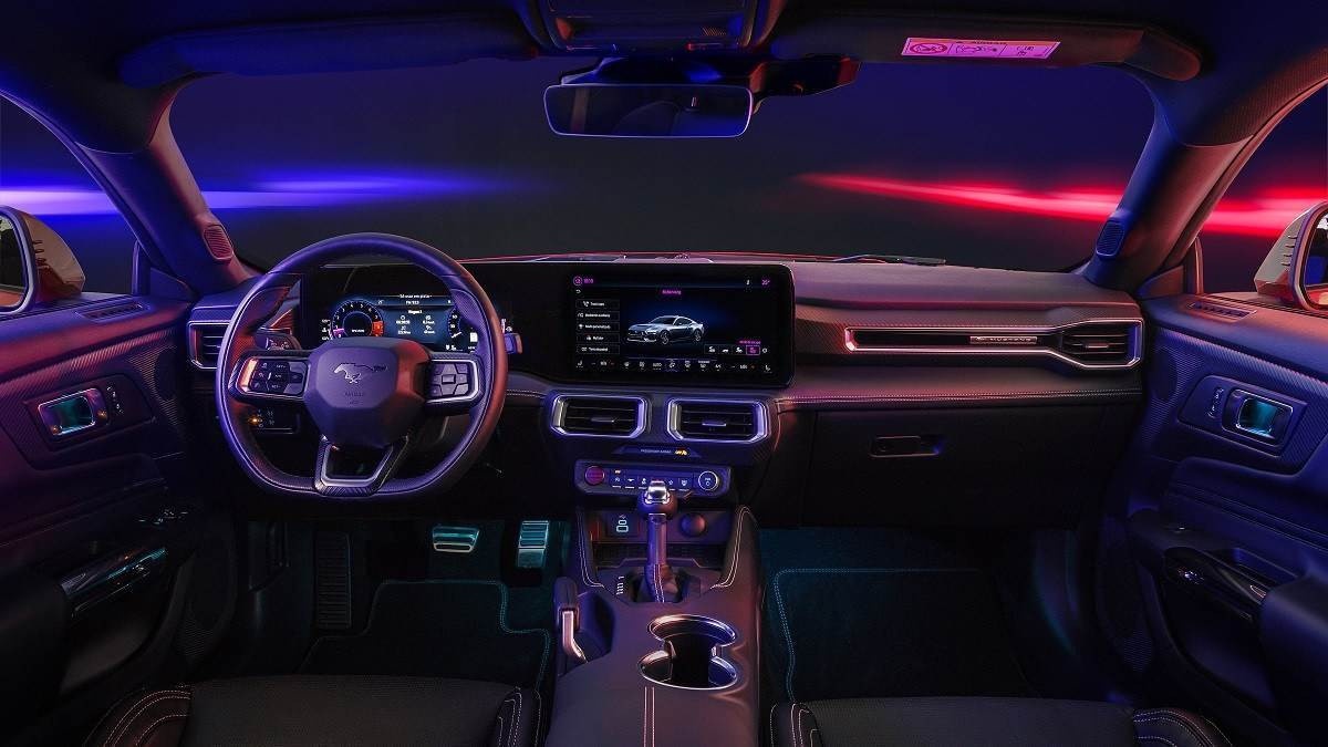 Interior do Ford Mustang GT Performance com luzes azuis e vermelhas vistas pelo para-brisas e janelas.