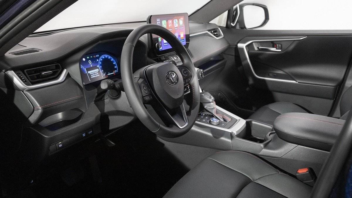 Interior do Toyota RAV4 XSE Plugin Hybrid com fundo branco visto pelo para-brisa e janela do passageiro