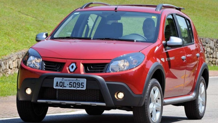 Renault Sandero Stepway 2008 vermelho, em movimento, com gramado ao fundo