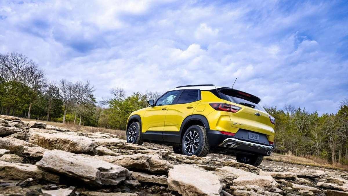 Chevrolet TrailBlazer amarelo em chão de pedra, com árvores e céu claro ao fundo