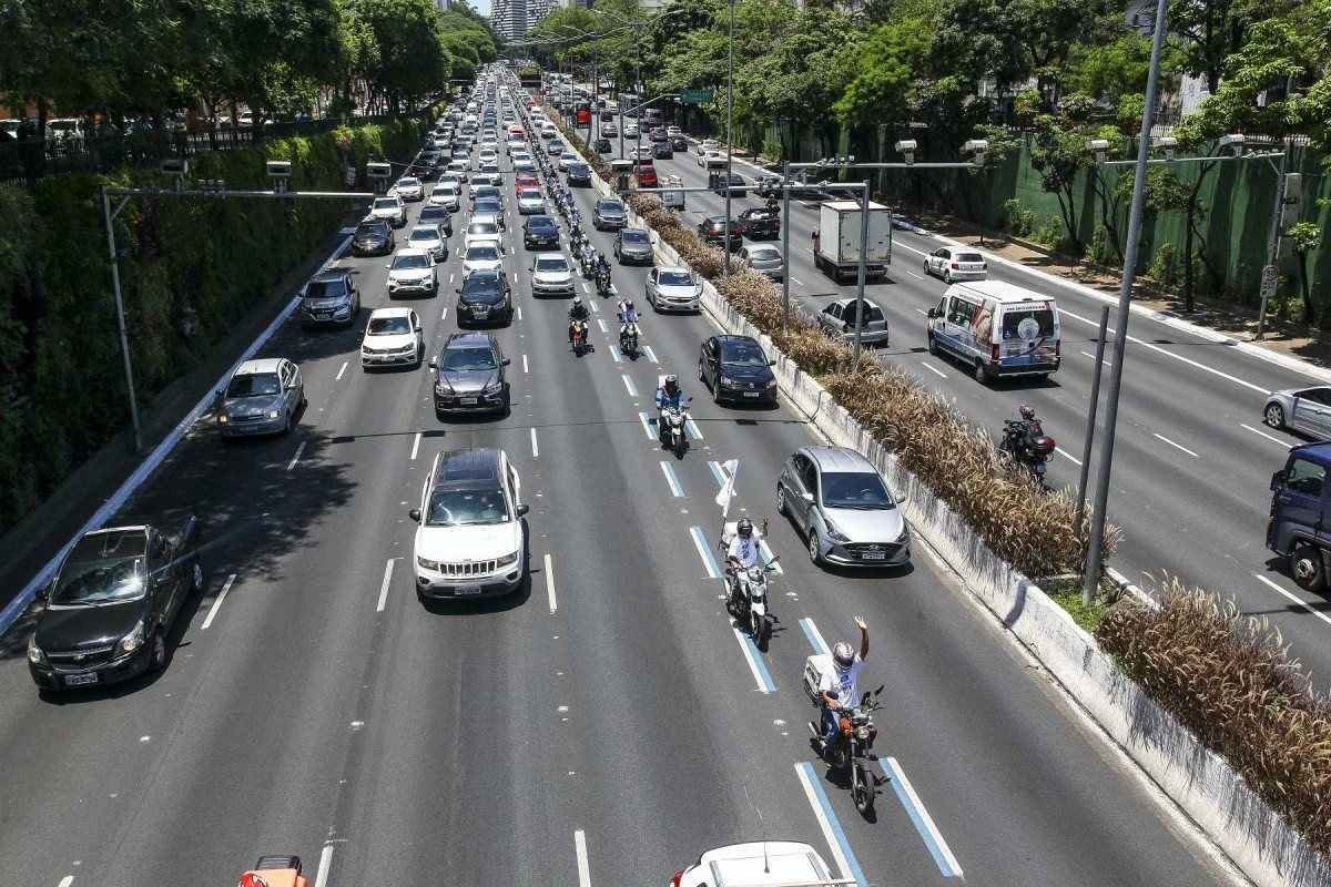 Trânsito de São Paulo em via com faixa Azul com motos e carros trafegando