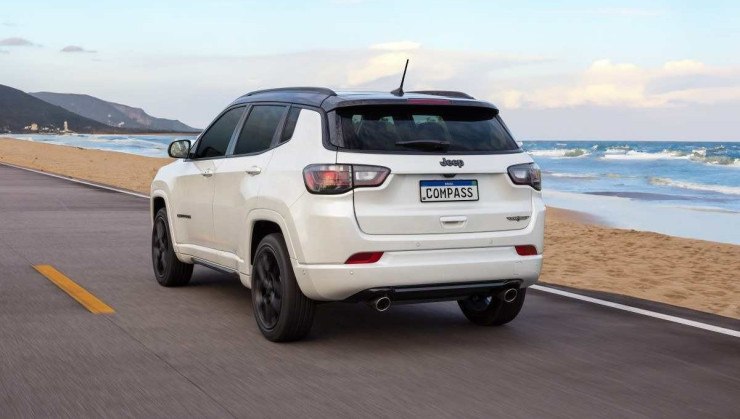 Jeep Compass Blackhawk modelo 2025 branco de traseira em movimento no asfalto