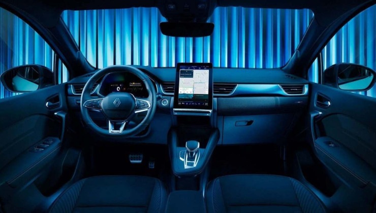 Interior do Renault Symbioz com tela de infoentretenimento ligada no painel com volante. É possível ver fundo azul iluminado pelo para-brisas e janelas do veículo